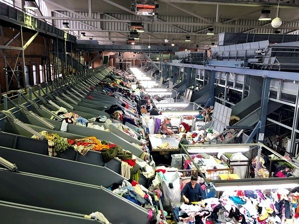 Sortieranlage mit Förderbändern und großen Mengen gemischter Textilien
